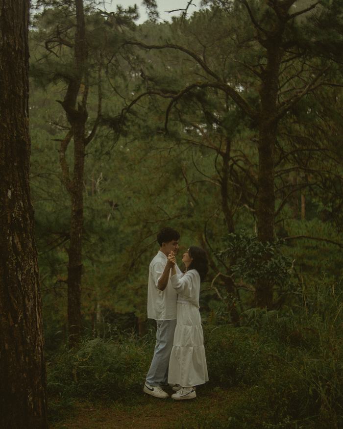 Bryan and Irey among the pines, caught mid-laugh.