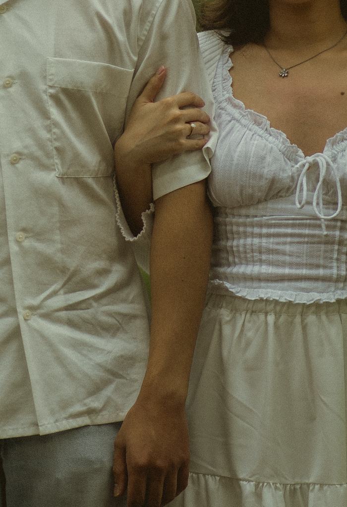 A quiet, close detail — Irey's hand resting on Bryan's arm.