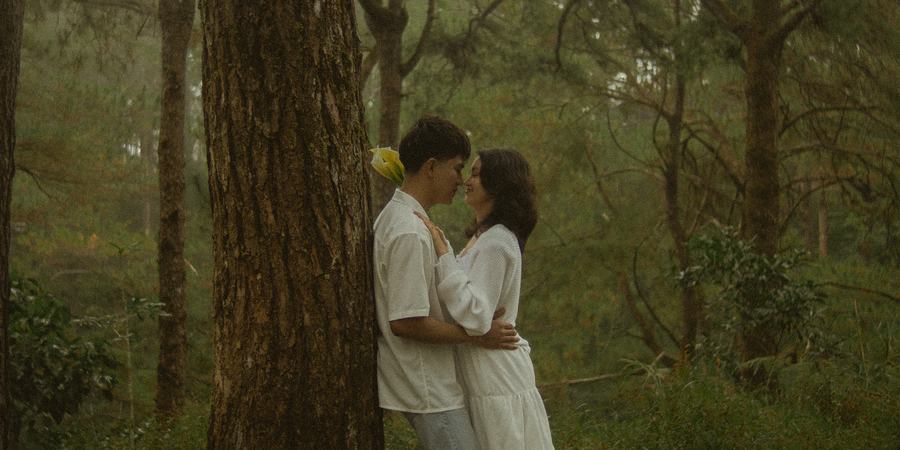 Bryan and Irey, close together beneath the pines.